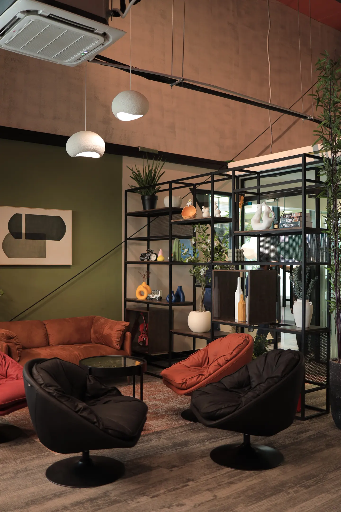 A quiet corner of the office with low seating, a glass table and plants.